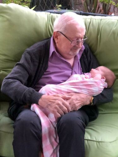 Frank on his 100th birthday holding his youngest great grandchild.